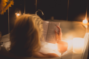 Relaxing woman in bathtub reading book