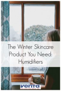 Woman standing in front of window applying new winter skincare routine