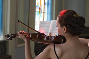 Woman playing wooden instrument violin in church