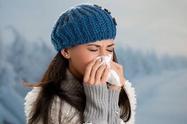 Sick woman blowing her nose during flu season