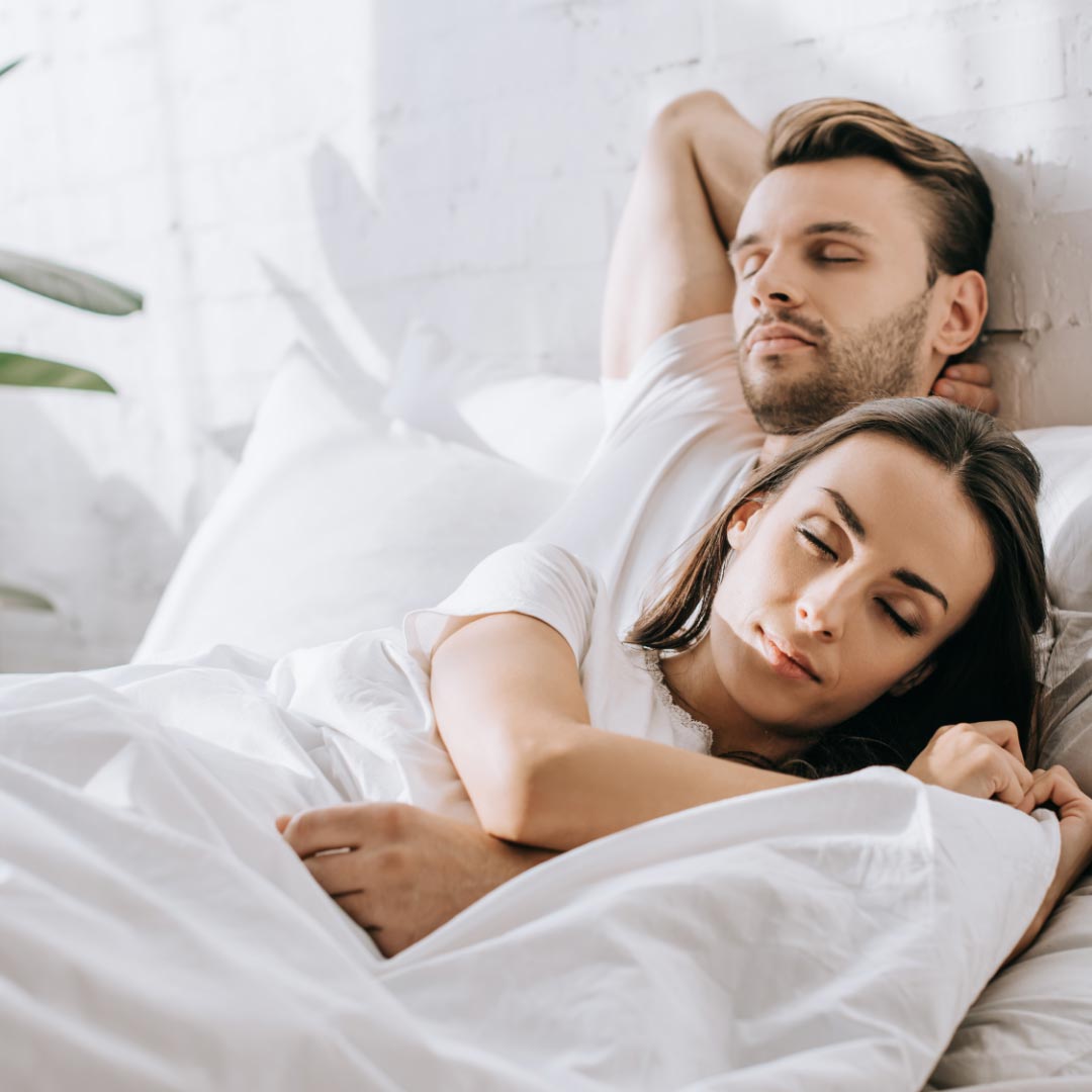 Pareja durmiendo en la cama.