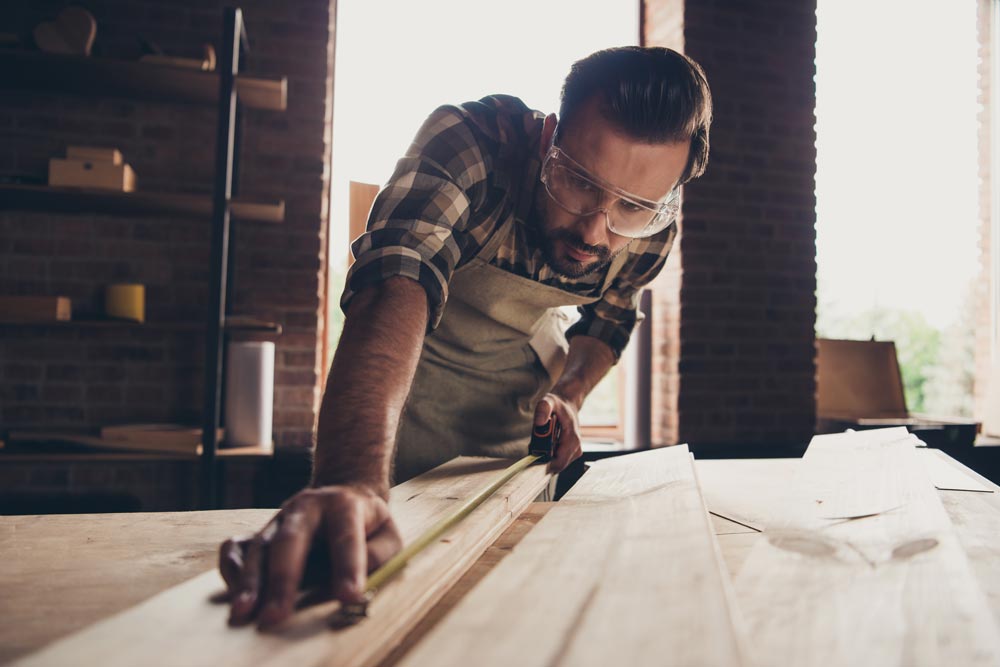 Uomo che posa un nuovo pavimento in legno.