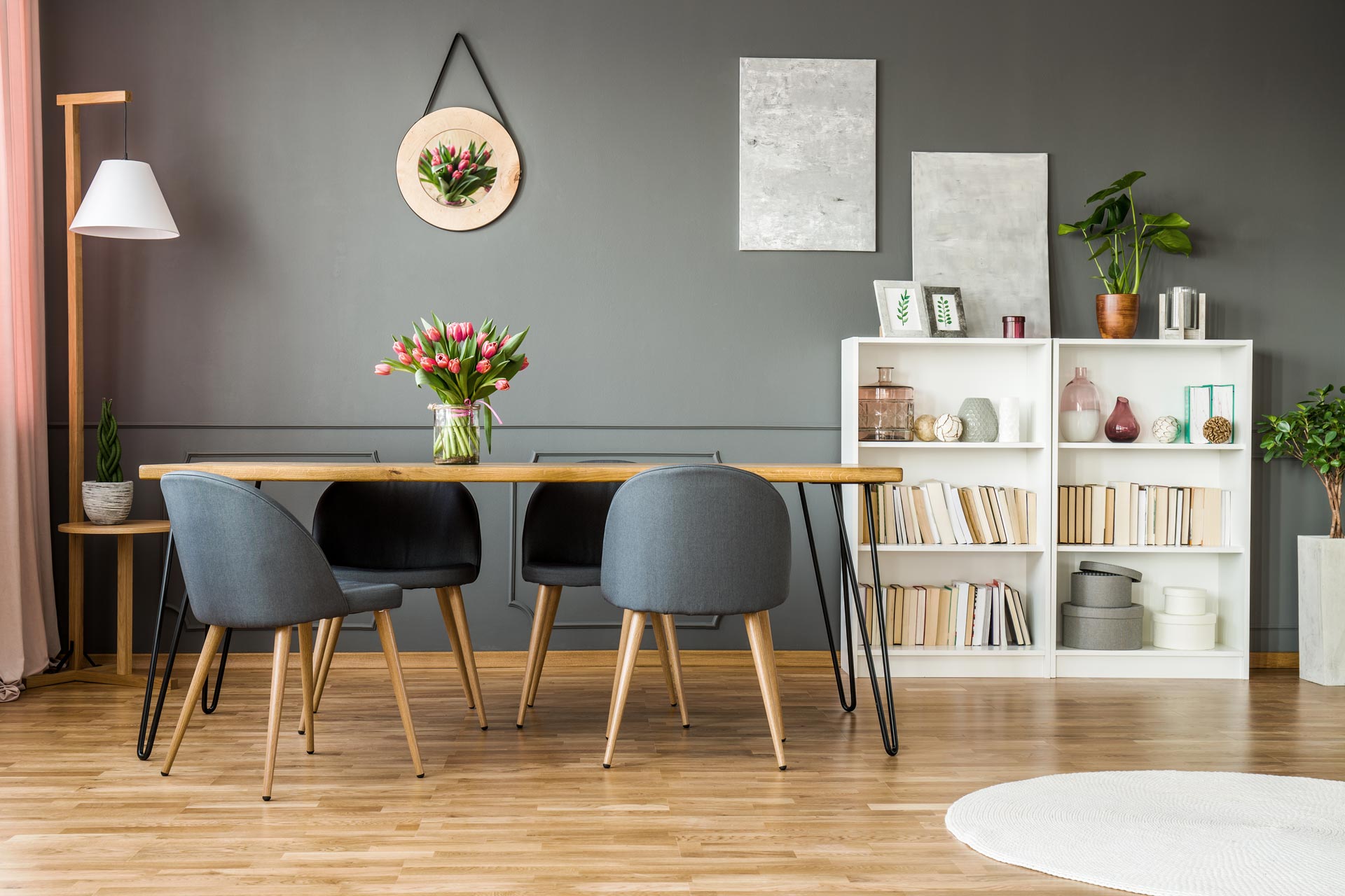 Salle à manger avec plancher en bois et bibliothèque.