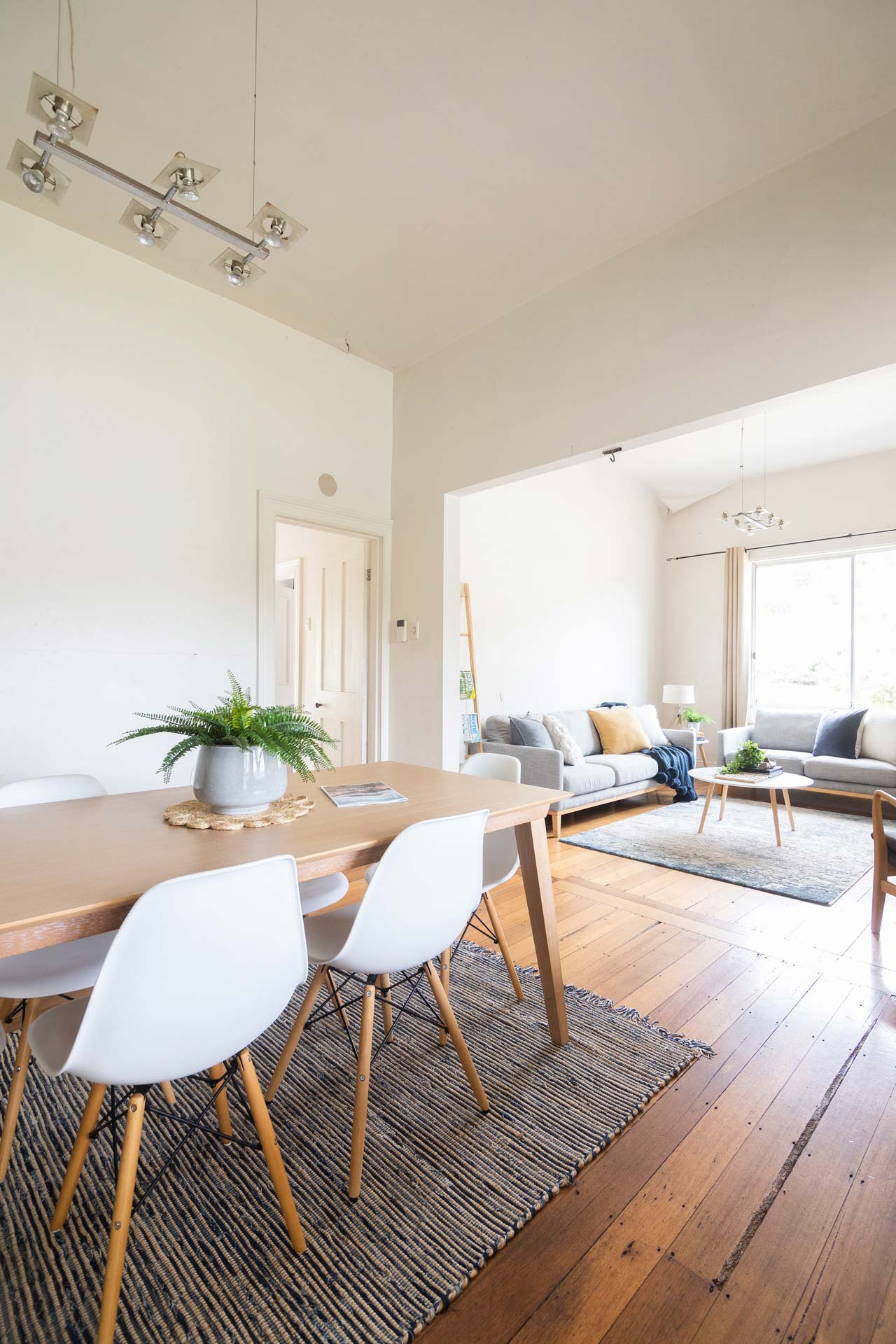 Vue sur une salle de séjour lumineuse avec salle à manger et coin salon.