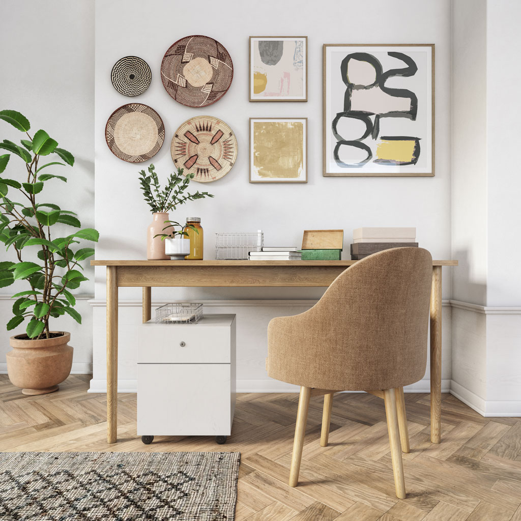 Home Office Schreibtisch mit gemütlichen Sessel und abstrakten Bildern an der Wand.